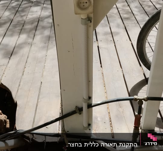 שקע חשמל מותקן על עמוד עץ עם כבלים